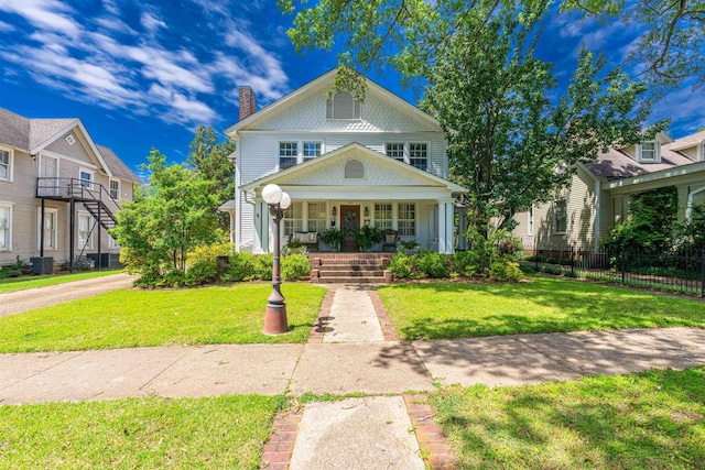 - view of front facade with a chimney, a porch, and central AC