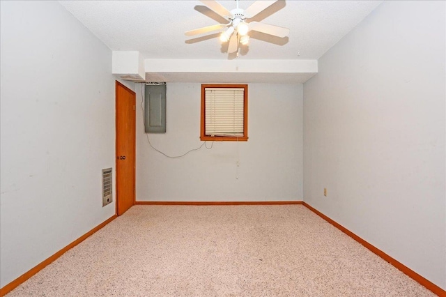 carpeted spare room featuring electric panel and ceiling fan