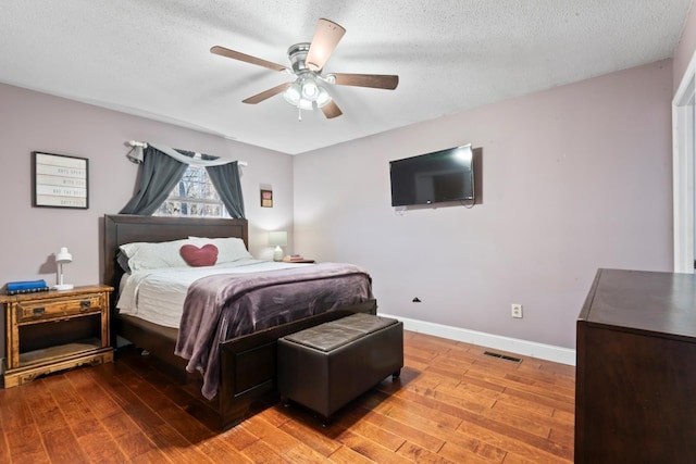 bedroom featuring a textured ceiling, light hardwood / wood-style flooring, and ceiling fan