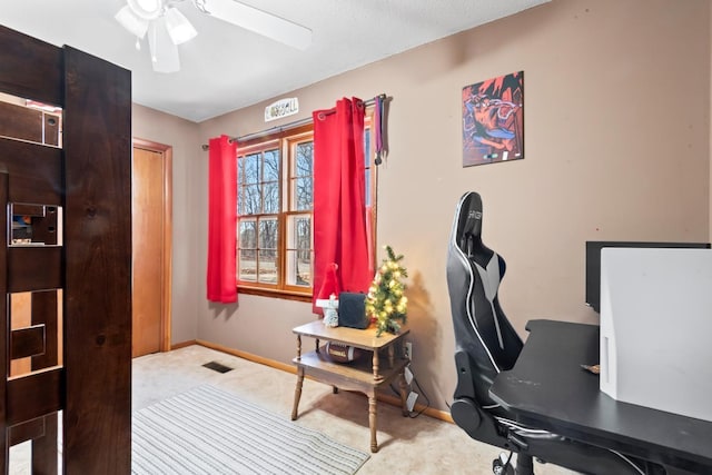 carpeted office space featuring ceiling fan