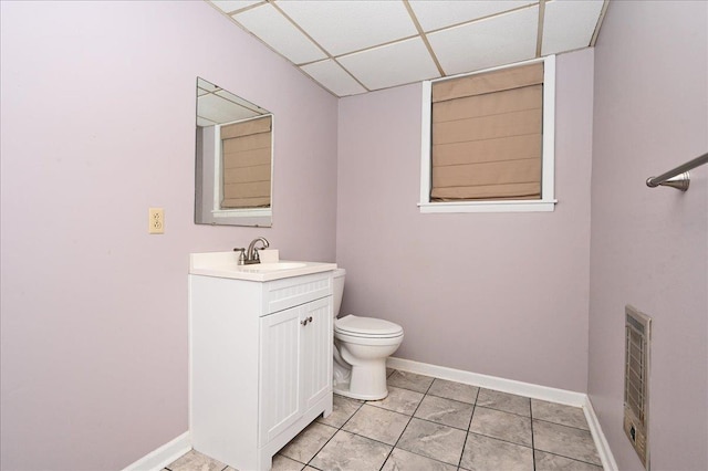 bathroom with vanity, toilet, and a paneled ceiling