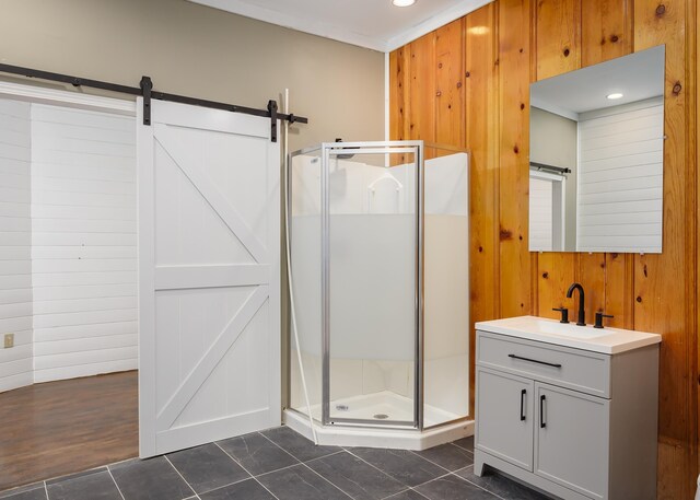 bathroom with tile patterned flooring, vanity, wood walls, and walk in shower