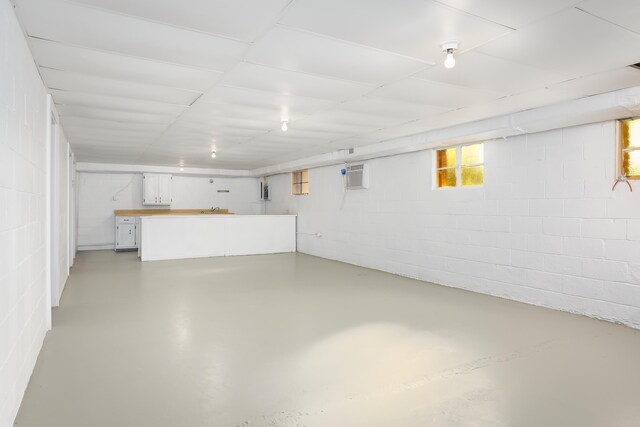 basement with a wall mounted air conditioner and sink