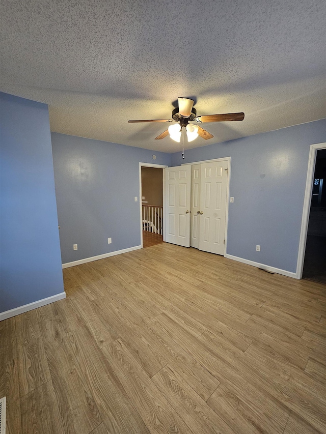 unfurnished bedroom with ceiling fan, a textured ceiling, and light hardwood / wood-style floors