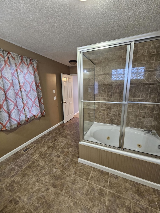 bathroom featuring a textured ceiling and shower / bath combination with glass door