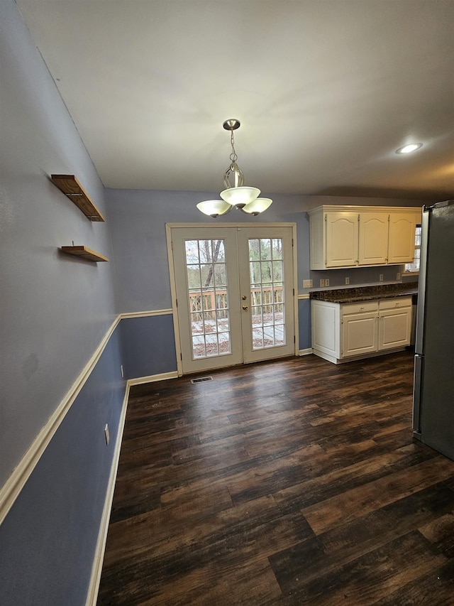 kitchen featuring white cabinetry, dark hardwood / wood-style floors, decorative light fixtures, french doors, and stainless steel refrigerator