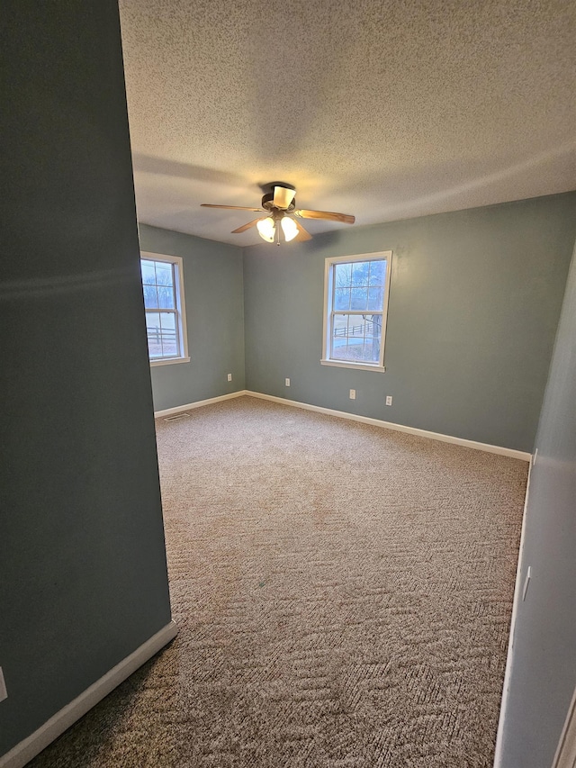 carpeted empty room featuring a textured ceiling and ceiling fan