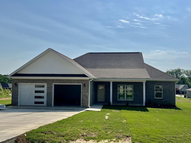 view of front of home with brick siding, an attached garage, driveway, and a front yard