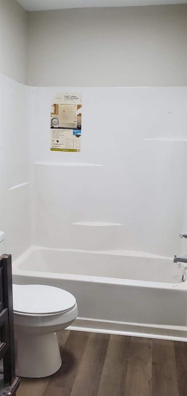 bathroom featuring wood-type flooring, a bathing tub, vanity, and toilet