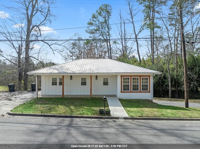  - view of front of house with metal roof, a front lawn, and board and batten siding