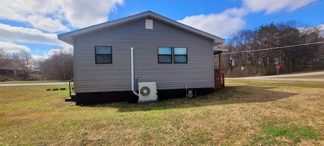 view of side of home with a lawn and ac unit