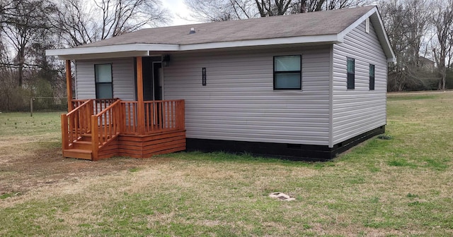 rear view of house featuring a lawn