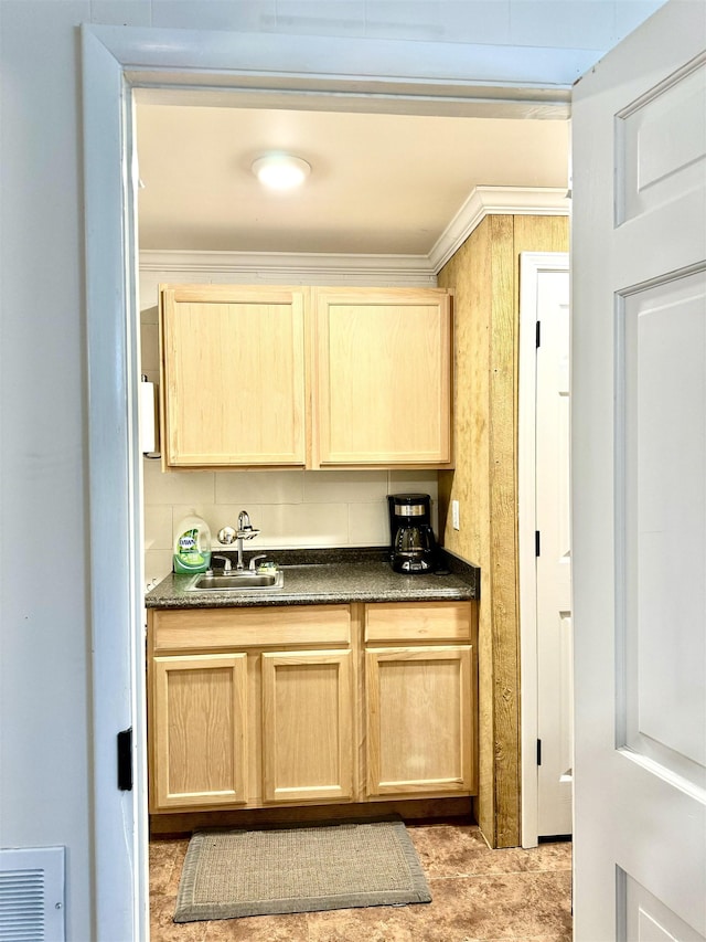 kitchen featuring light brown cabinetry, decorative backsplash, sink, and ornamental molding