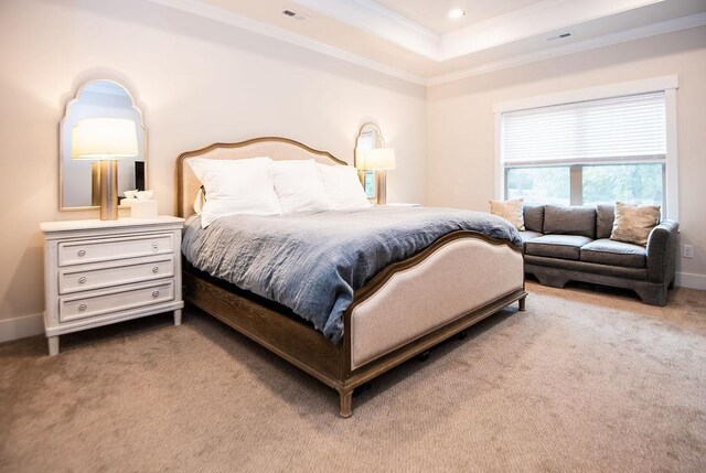 bedroom with carpet, crown molding, and a tray ceiling