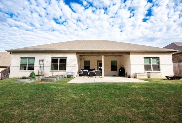 back of property with a yard and a patio area