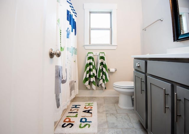 bathroom featuring tile patterned flooring, vanity, toilet, and walk in shower