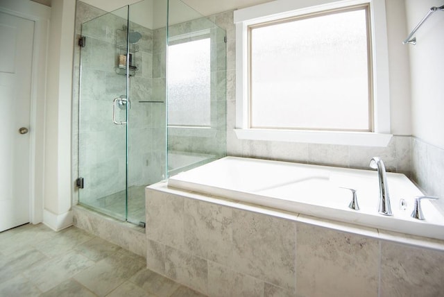 bathroom featuring shower with separate bathtub