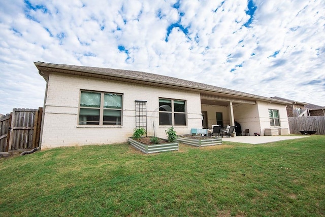 back of house with a lawn and a patio