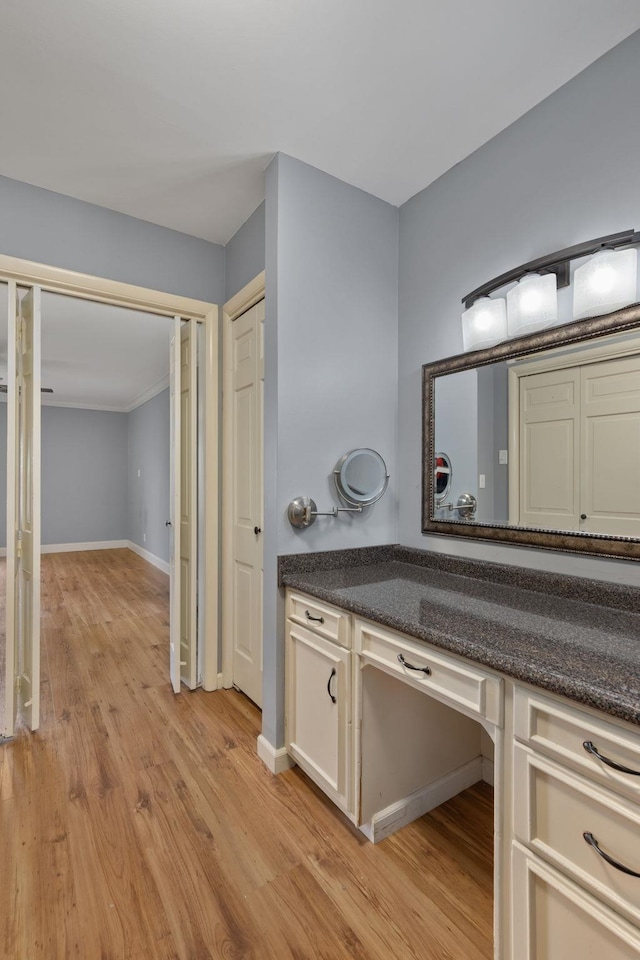  - bathroom with wood finished floors, baseboards, and vanity
