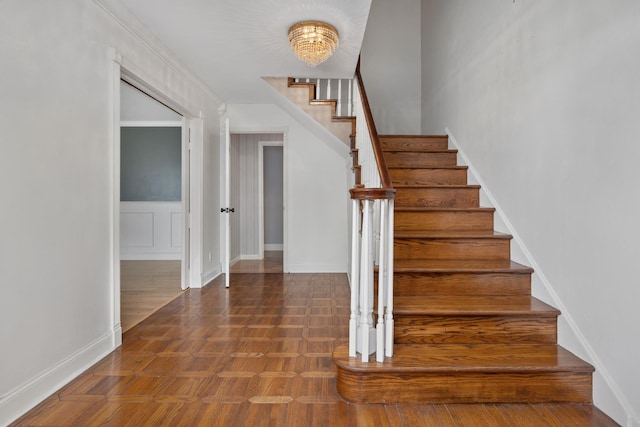  - stairway with baseboards and a chandelier