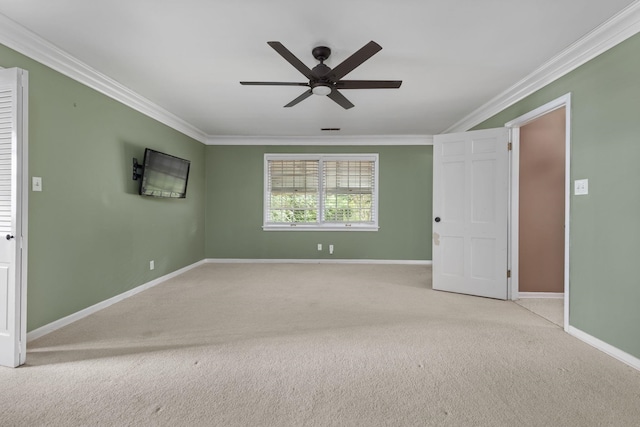  - carpeted empty room with crown molding, a ceiling fan, and baseboards
