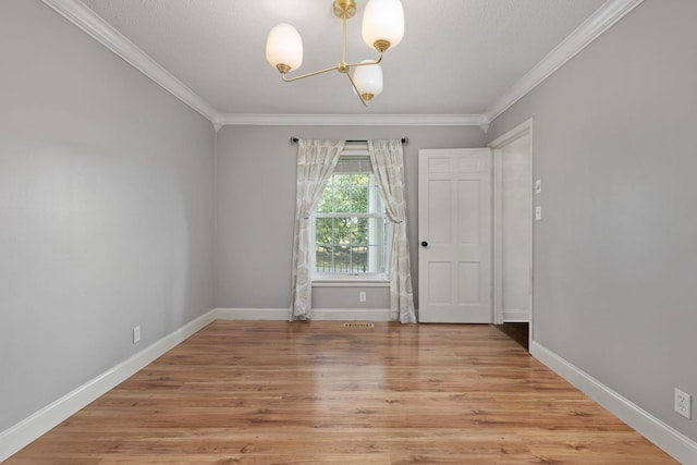  - empty room with a chandelier, crown molding, light wood-type flooring, and baseboards