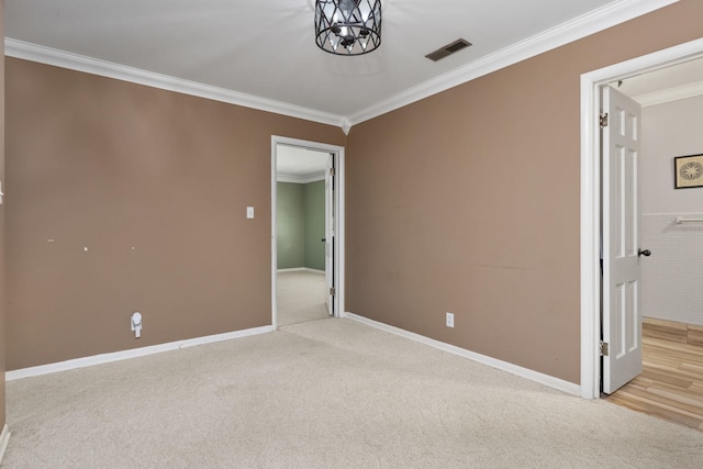  - carpeted spare room with ornamental molding, a chandelier, and baseboards
