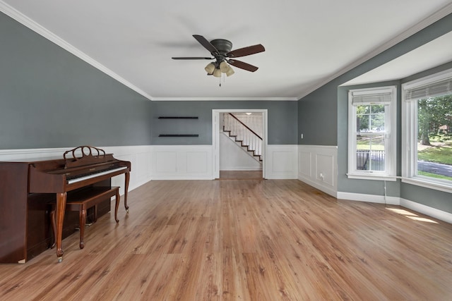  - living room with stairs, wood finished floors, ceiling fan, a wainscoted wall, and crown molding