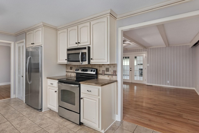  - kitchen with appliances with stainless steel finishes, baseboards, light tile patterned floors, tasteful backsplash, and beam ceiling