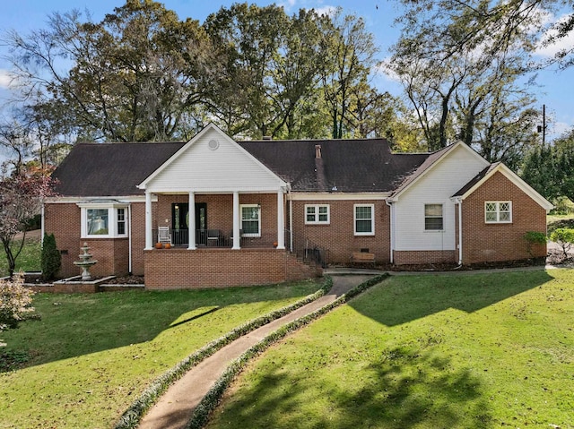 rear view of property featuring a lawn and covered porch