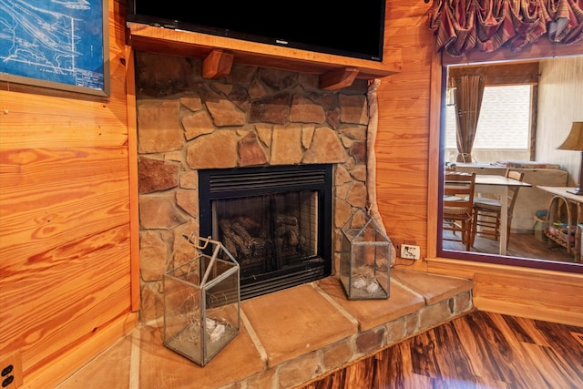  - detailed view of a fireplace, wood finished floors, and wooden walls