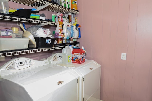 laundry room featuring washer and dryer and wood walls