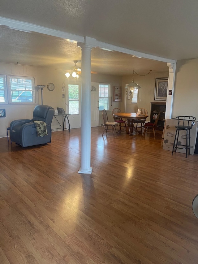 living room with ornate columns, a healthy amount of sunlight, hardwood / wood-style flooring, and ceiling fan