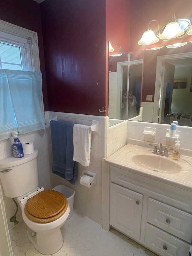 bathroom featuring vanity, tile walls, tile patterned floors, and toilet