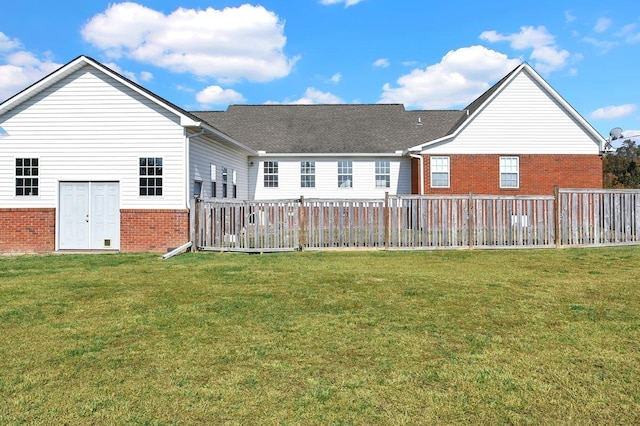 rear view of house featuring a lawn