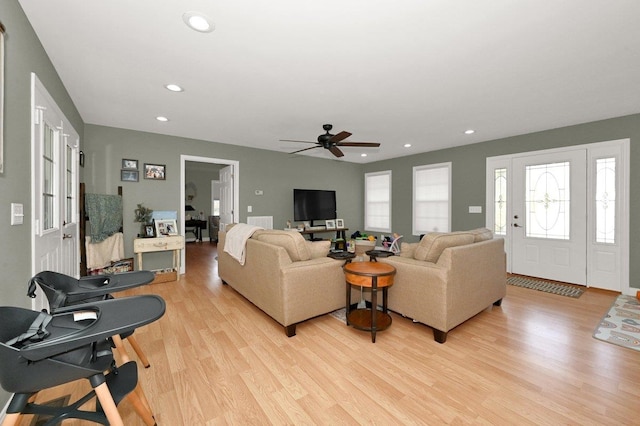 living room with ceiling fan and light hardwood / wood-style flooring