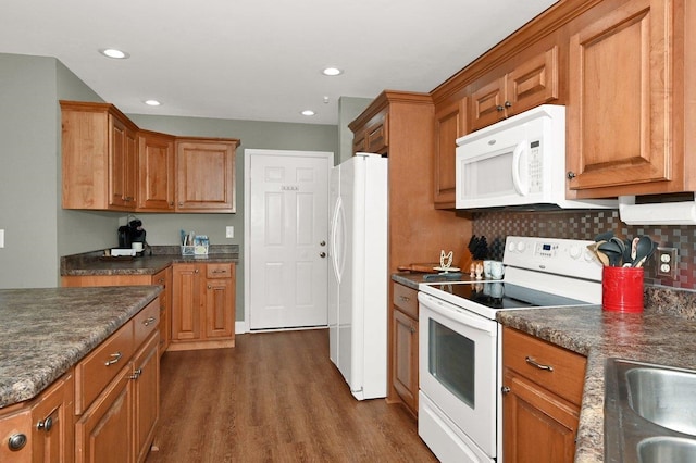 kitchen featuring dark hardwood / wood-style floors, white appliances, sink, and tasteful backsplash