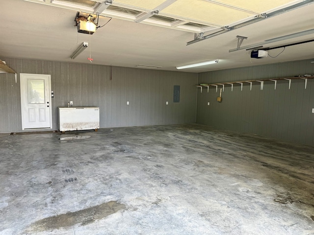 garage featuring electric panel, a garage door opener, and wooden walls