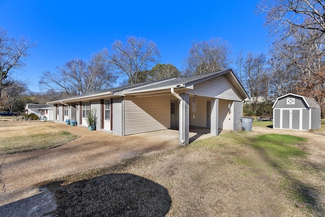 view of home's exterior with a yard, a carport, and a storage unit