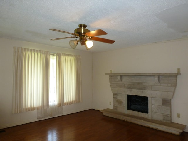  - unfurnished living room with wood finished floors, ceiling fan, and a fireplace