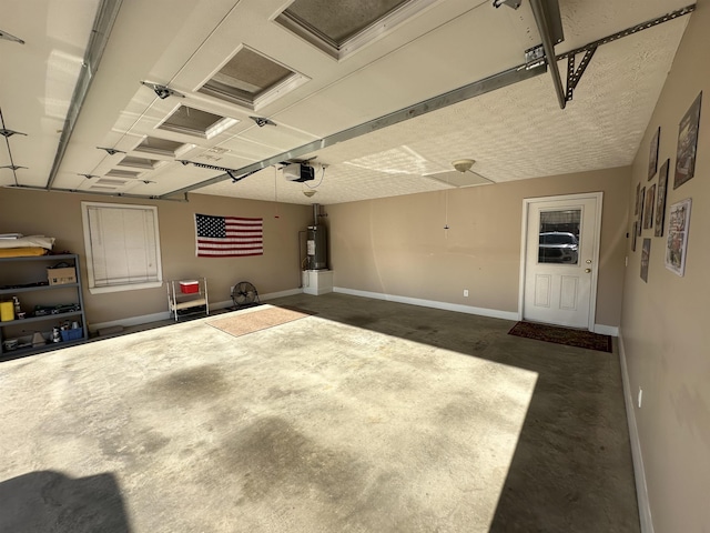 garage featuring baseboards, electric water heater, and a garage door opener