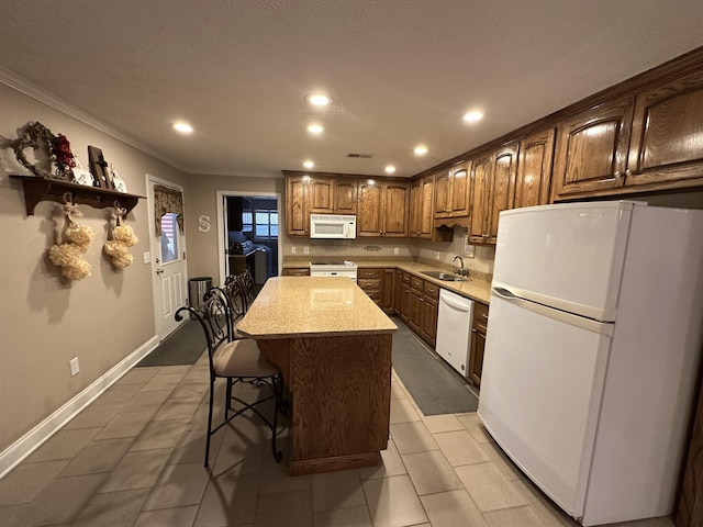 kitchen with a sink, crown molding, white appliances, a kitchen island, and recessed lighting