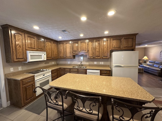 kitchen with recessed lighting, visible vents, a sink, and white appliances