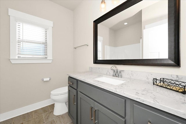 bathroom with tile patterned flooring, vanity, toilet, and walk in shower