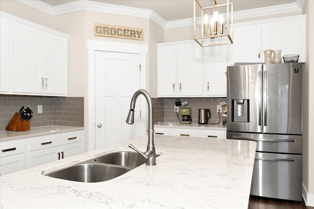 kitchen featuring backsplash, stainless steel fridge, sink, and white cabinets