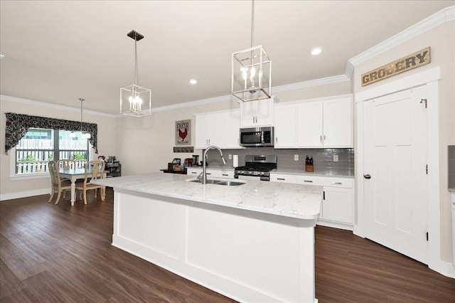 kitchen featuring a center island with sink, pendant lighting, sink, and stainless steel appliances