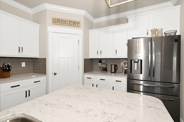 kitchen with white cabinets, stainless steel refrigerator with ice dispenser, and tasteful backsplash