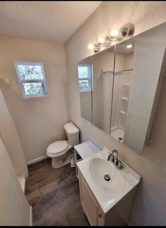 bathroom featuring plenty of natural light, vanity, a textured ceiling, and hardwood / wood-style flooring