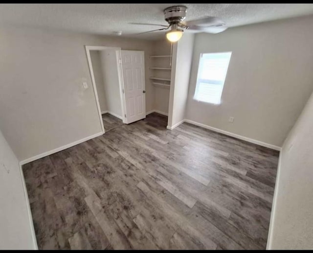 unfurnished bedroom with ceiling fan, dark hardwood / wood-style floors, a textured ceiling, and a closet