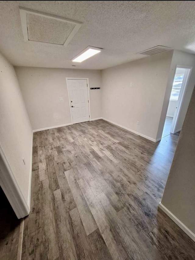 empty room with hardwood / wood-style floors and a textured ceiling